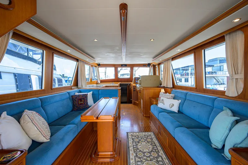 Teal Aweigh Yacht Photos Pics Luxurious interior of 2011 Grand Banks 41 Europa yacht with blue seating and wooden accents.