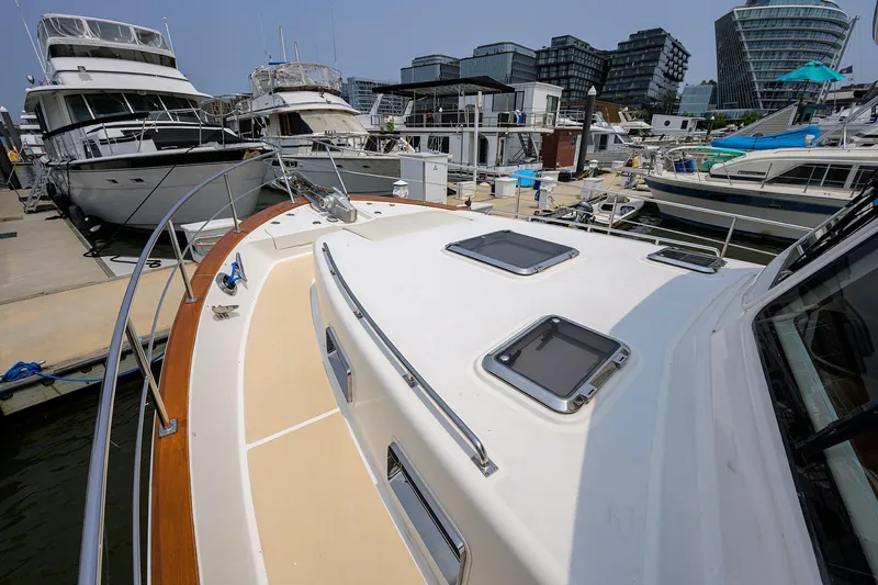 Teal Aweigh Yacht Photos Pics 2011 Grand Banks 41 Europa yacht docked at a marina with modern buildings in the background.