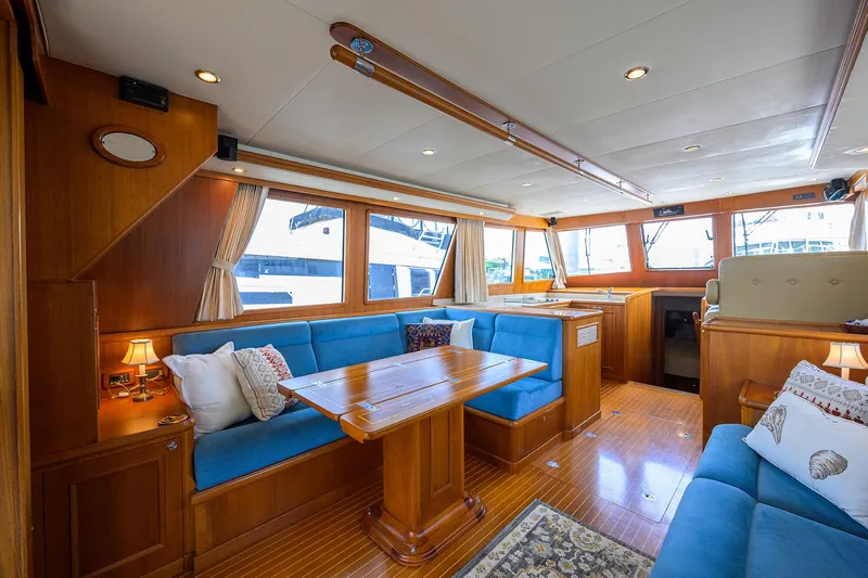 Teal Aweigh Yacht Photos Pics Luxurious interior of 2011 Grand Banks 41 Europa yacht with blue seating and wooden accents.