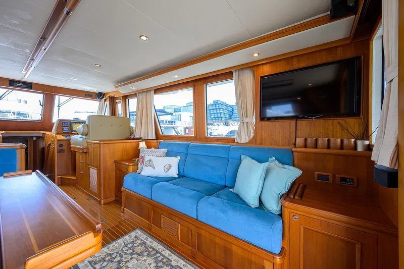 Teal Aweigh Yacht Photos Pics Luxurious interior of 2011 Grand Banks 41 Europa yacht with blue seating and wood finish.