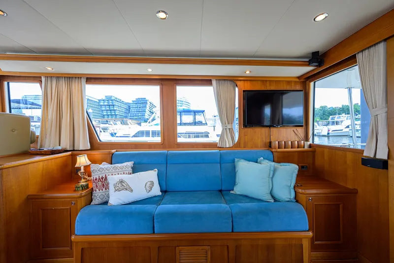 Teal Aweigh Yacht Photos Pics Luxurious interior of 2011 Grand Banks 41 Europa yacht with blue sofa and scenic windows.