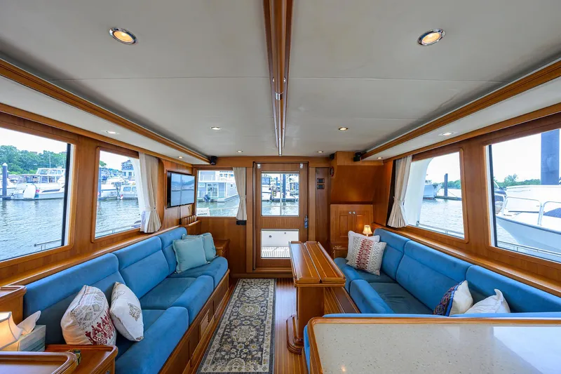 Teal Aweigh Yacht Photos Pics Luxurious interior of 2011 Grand Banks 41 Europa yacht with blue seating and wood accents.