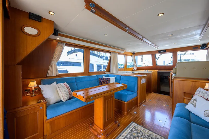 Teal Aweigh Yacht Photos Pics Luxurious interior of 2011 Grand Banks 41 Europa yacht with blue seating and wooden accents.