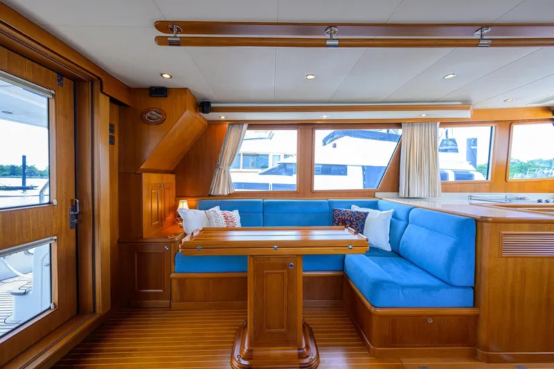 Teal Aweigh Yacht Photos Pics Luxurious interior of 2011 Grand Banks 41 Europa yacht with blue seating and wooden finishes.