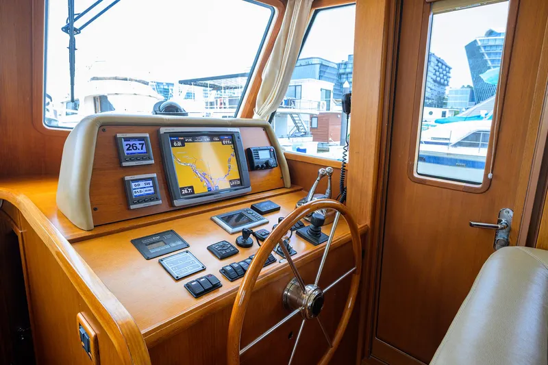 Teal Aweigh Yacht Photos Pics Helm of 2011 Grand Banks 41 Europa yacht with navigation instruments and wooden steering wheel.