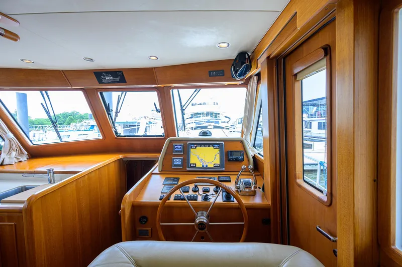 Teal Aweigh Yacht Photos Pics Interior helm of 2011 Grand Banks 41 Europa yacht with wooden finish and navigation equipment.