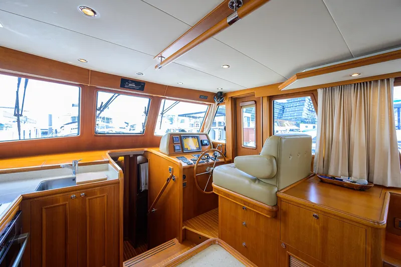 Teal Aweigh Yacht Photos Pics Luxurious 2011 Grand Banks 41 Europa yacht interior with helm, wood finish, and large windows.