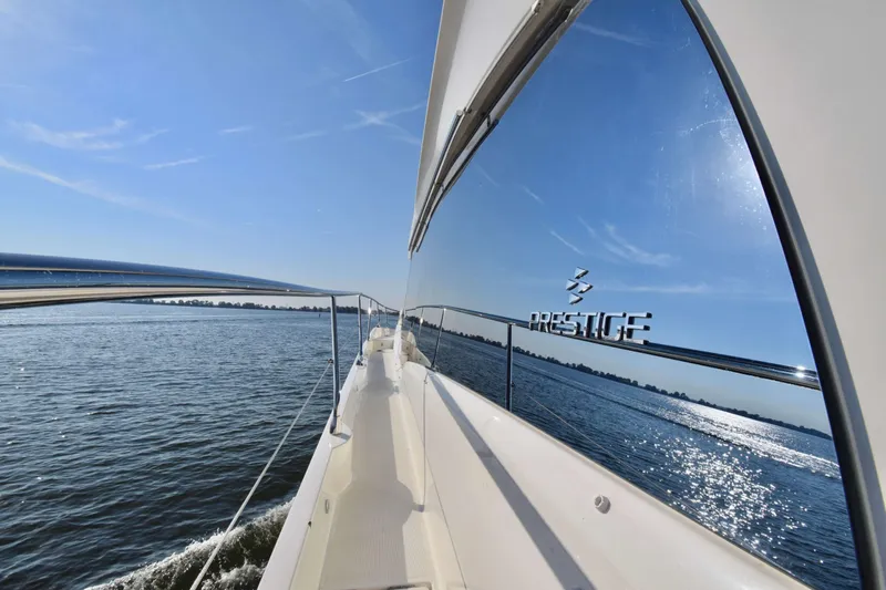  Yacht Photos Pics Prestige 590 yacht cruising on a sunny day, reflecting water and sky, 2019 model.