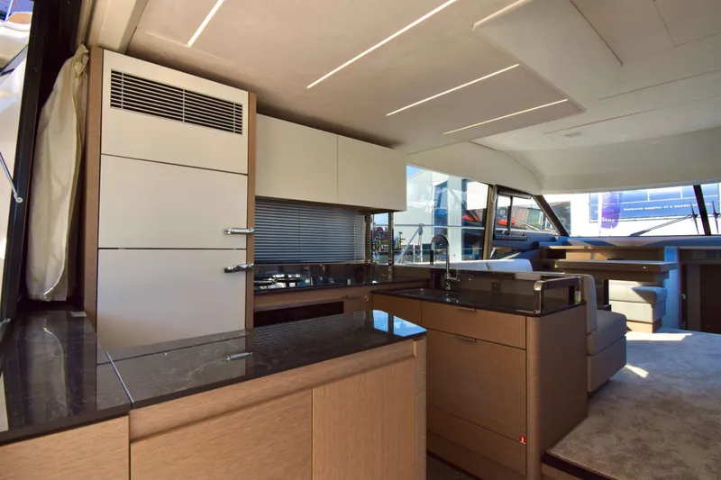  Yacht Photos Pics Luxurious interior of 2019 Prestige 590 yacht with modern kitchen and seating area.