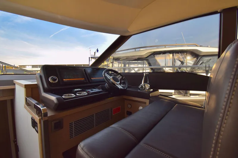  Yacht Photos Pics Interior view of 2019 Prestige 590 yacht cockpit with steering wheel and control panel.