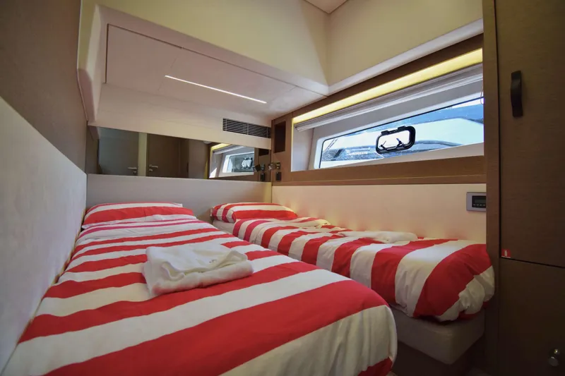  Yacht Photos Pics Twin beds with red-striped bedding in a 2019 Prestige 590 yacht cabin.