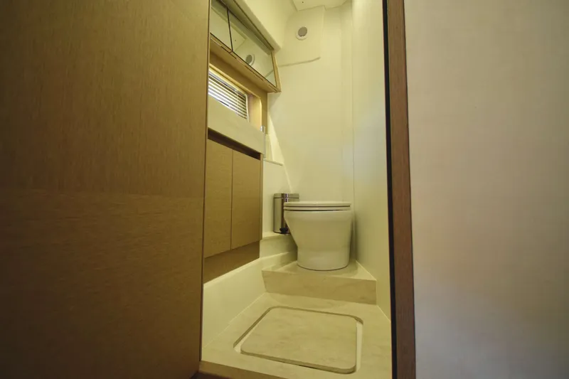  Yacht Photos Pics Luxurious bathroom in 2019 Prestige 590 yacht with modern fixtures and wooden cabinetry.