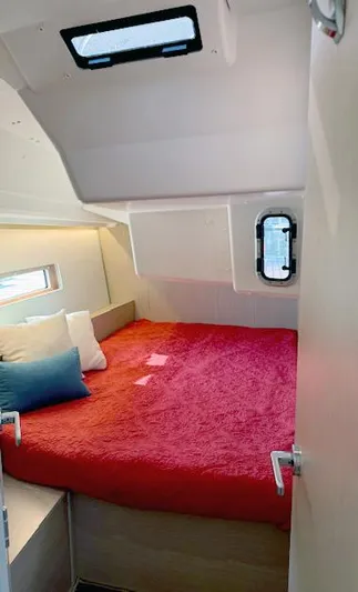  Yacht Photos Pics 2023 Beneteau Oceanis 40.1 cabin with red bedding and porthole window.