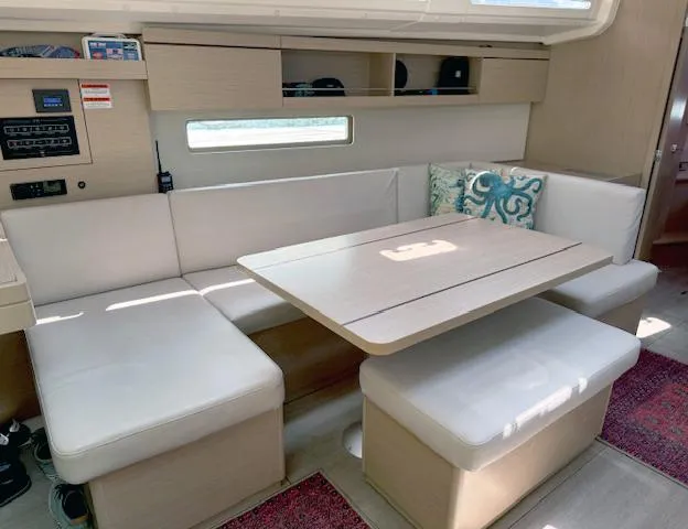  Yacht Photos Pics 2023 Beneteau Oceanis 40.1 interior with beige seating and wooden table.