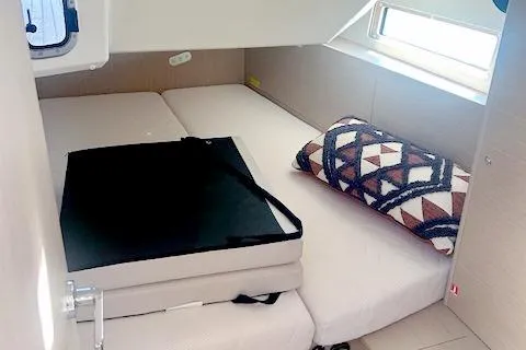  Yacht Photos Pics 2023 Beneteau Oceanis 40.1 cabin interior with bed, window, and geometric pillow.
