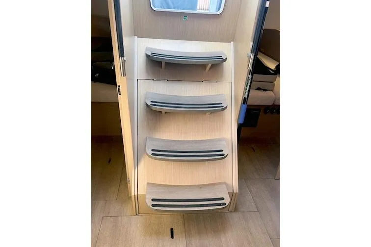  Yacht Photos Pics Staircase inside 2023 Beneteau Oceanis 40.1 yacht, featuring sleek wooden steps.