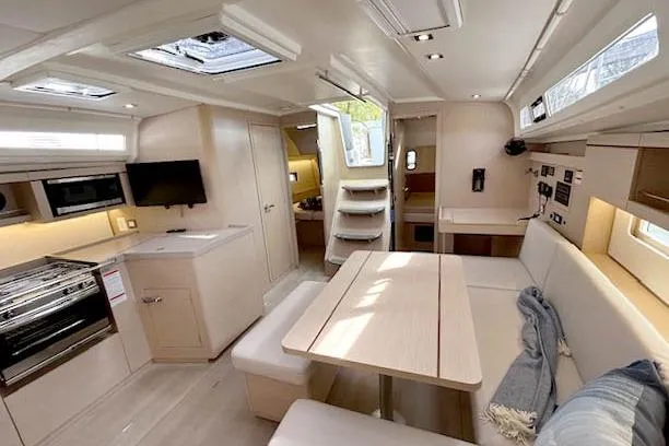  Yacht Photos Pics Modern interior of 2023 Beneteau Oceanis 40.1 yacht with spacious seating and kitchen area.