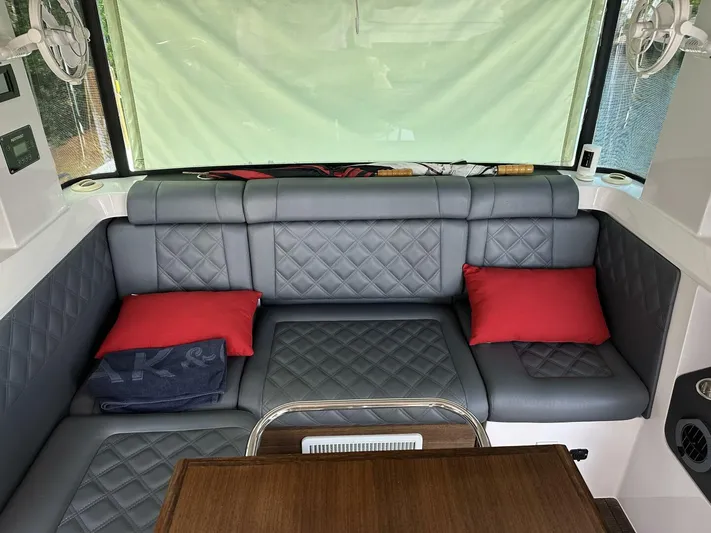  Yacht Photos Pics Luxurious interior of 2021 Axopar 37 XC Cross Cabin Brabus with quilted seating and red cushions.