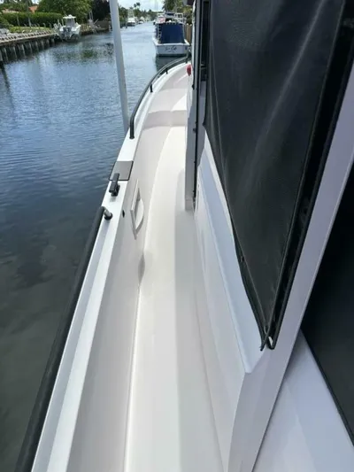  Yacht Photos Pics 2021 Axopar 37 XC Cross Cabin Brabus side deck view on a calm waterway.