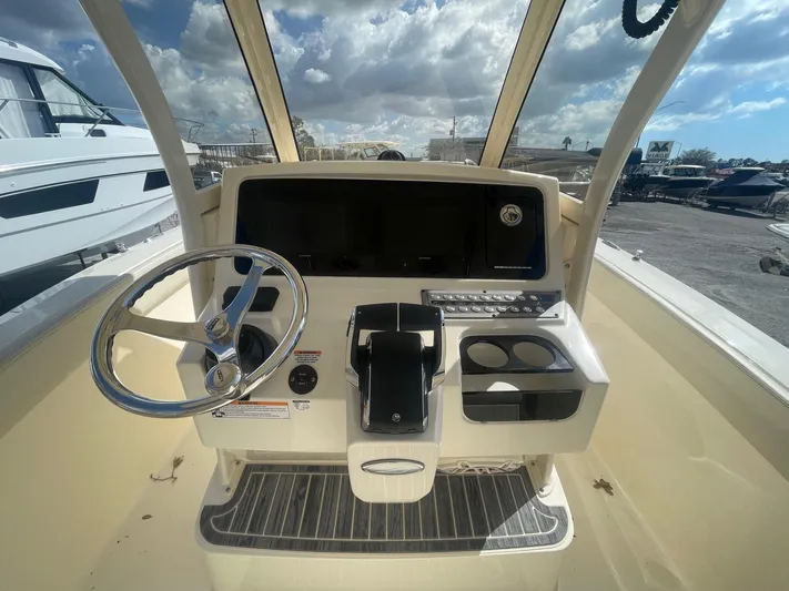  Yacht Photos Pics 2025 Scout 277 LXF boat helm with steering wheel and control panel.