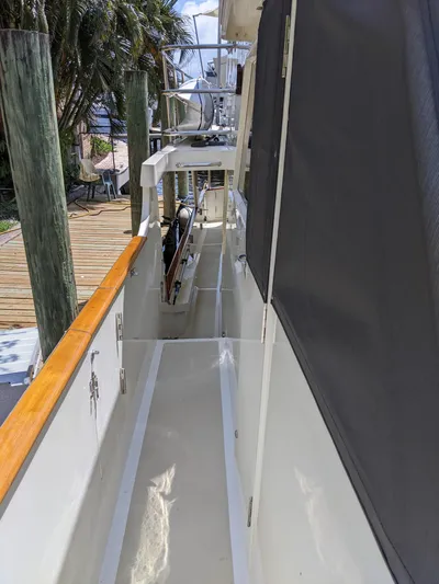 Pura Vida III Yacht Photos Pics 1999 Grand Alaskan Pilothouse yacht side deck with wooden railings and dock view.