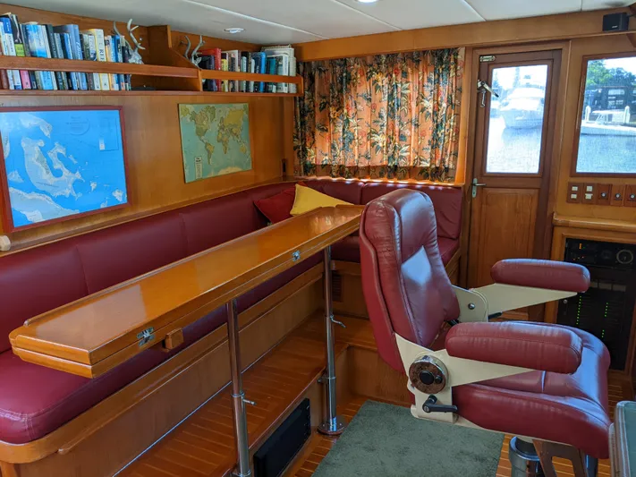 Pura Vida III Yacht Photos Pics 1999 Grand Alaskan Pilothouse interior with red leather seating, maps, and bookshelves.