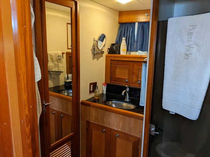 Pura Vida III Yacht Photos Pics 1999 Grand Alaskan Pilothouse bathroom with wooden cabinetry and sink.