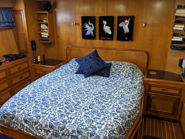 Pura Vida III Yacht Photos Pics 1999 Grand Alaskan Pilothouse master bedroom with wooden interior and a large bed.