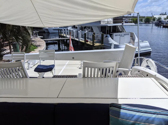 Pura Vida III Yacht Photos Pics 1999 Grand Alaskan Pilothouse yacht deck with white chairs and table under a canopy.