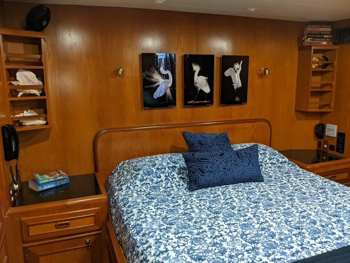 Pura Vida III Yacht Photos Pics 1999 Grand Alaskan Pilothouse bedroom with wooden walls, bed, and bird artwork.