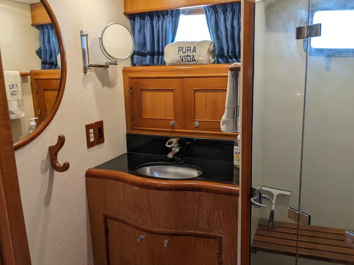 Pura Vida III Yacht Photos Pics 1999 Grand Alaskan Pilothouse bathroom with wooden cabinetry and glass shower.