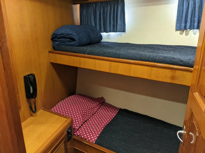 Pura Vida III Yacht Photos Pics 1999 Grand Alaskan Pilothouse bunk beds with wooden cabinetry and a wall-mounted phone.