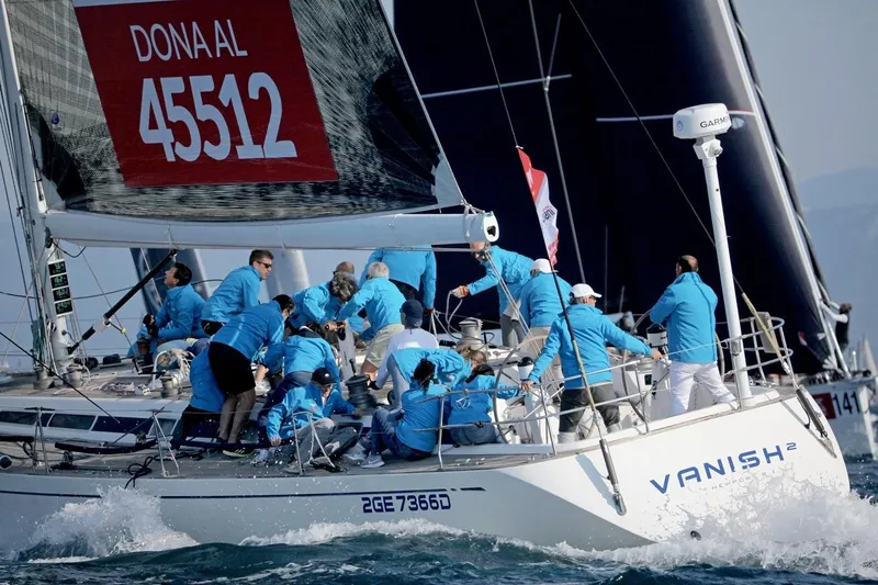 Vanish 2 Yacht Photos Pics Crew sailing a 1999 Nautor Swan 56 yacht during a race, wearing blue jackets.