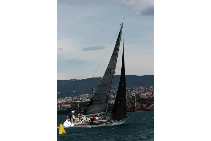 Vanish 2 Yacht Photos Pics Sailing yacht Nautor Swan 56 (1999) on water with cityscape background.