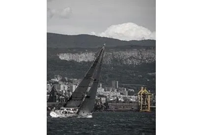 Vanish 2 Yacht Photos Pics Sailing yacht Nautor Swan 56 (1999) navigating near coastal cityscape and mountains.