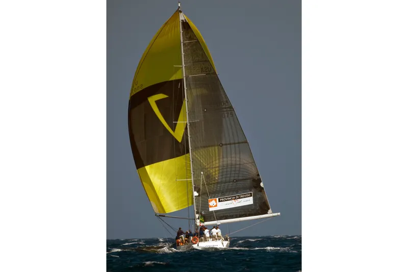 Vanish 2 Yacht Photos Pics Sailing yacht Nautor Swan 56 (1999) with vibrant yellow sail on open sea.