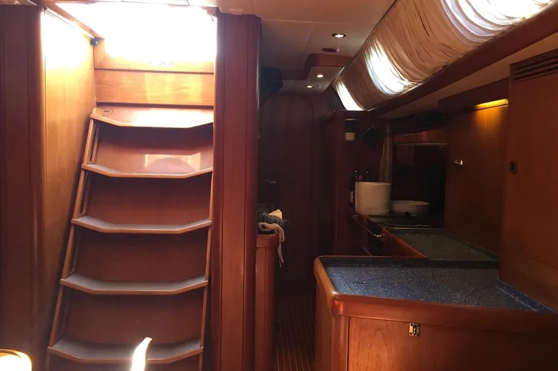 Vanish 2 Yacht Photos Pics Interior of 1999 Nautor Swan 56 yacht with wooden stairs and kitchen area.