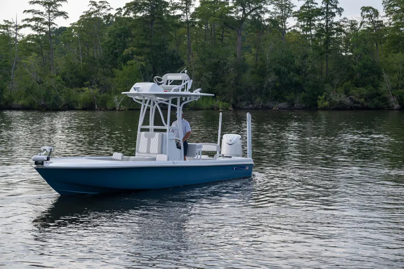  Yacht Photos Pics 2025 Contender 26 Bay boat on calm water with forested background.