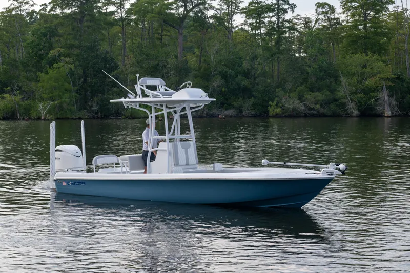  Yacht Photos Pics 2025 Contender 26 Bay boat on calm water, surrounded by lush greenery.