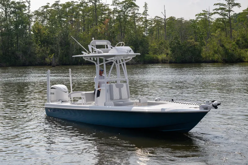  Yacht Photos Pics 2025 Contender 26 Bay boat on a calm river with lush greenery.