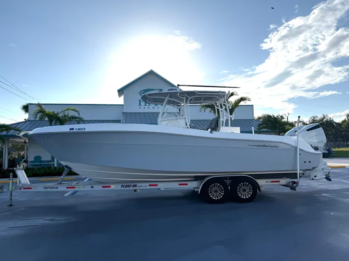  Yacht Photos Pics 2022 Aquasport 3000CC boat on trailer, parked outside a yacht dealership.