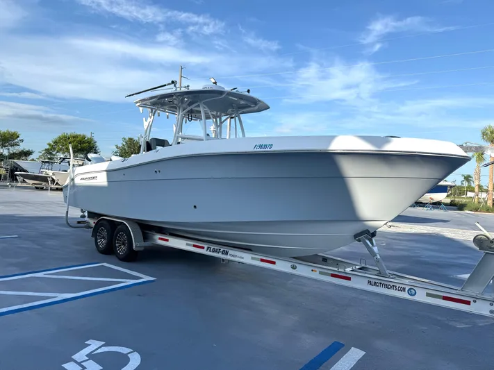  Yacht Photos Pics 2022 Aquasport 3000CC boat on trailer in parking lot under blue sky.