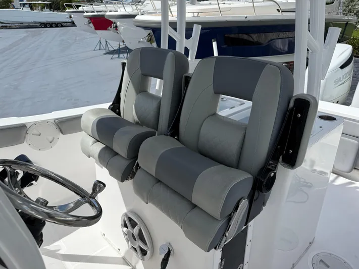  Yacht Photos Pics 2022 Aquasport 3000CC boat interior with dual gray seats and steering wheel.