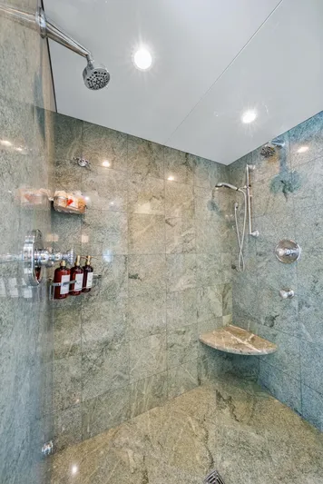 Nicole Evelyn Yacht Photos Pics Luxurious marble shower in 2005 Trinity Yachts Tri-Deck, featuring modern fixtures and amenities.