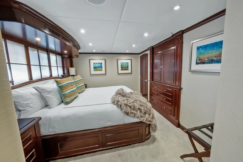Nicole Evelyn Yacht Photos Pics Luxurious bedroom in 2005 Trinity Yachts Tri-Deck with elegant wood furnishings.