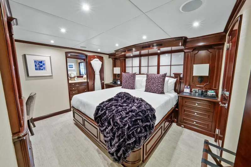 Nicole Evelyn Yacht Photos Pics Luxurious bedroom on 2005 Trinity Yachts Tri-Deck with elegant wood furnishings and plush bedding.