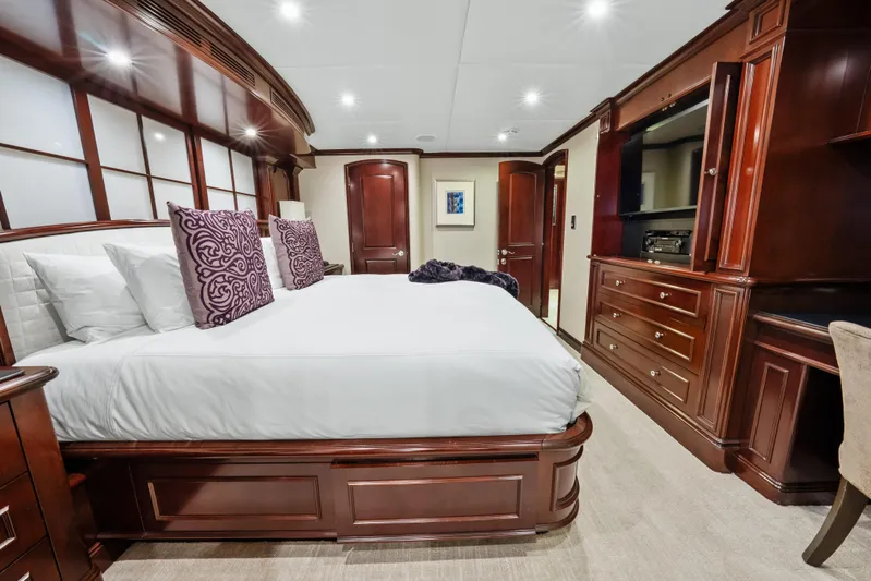 Nicole Evelyn Yacht Photos Pics Luxurious bedroom interior on 2005 Trinity Yachts Tri-Deck, featuring elegant wood furnishings.