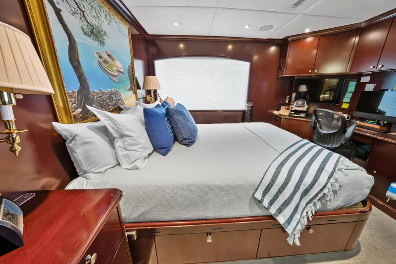Nicole Evelyn Yacht Photos Pics Luxurious bedroom interior on 2005 Trinity Yachts Tri-Deck, featuring elegant wood finishes and cozy bedding.