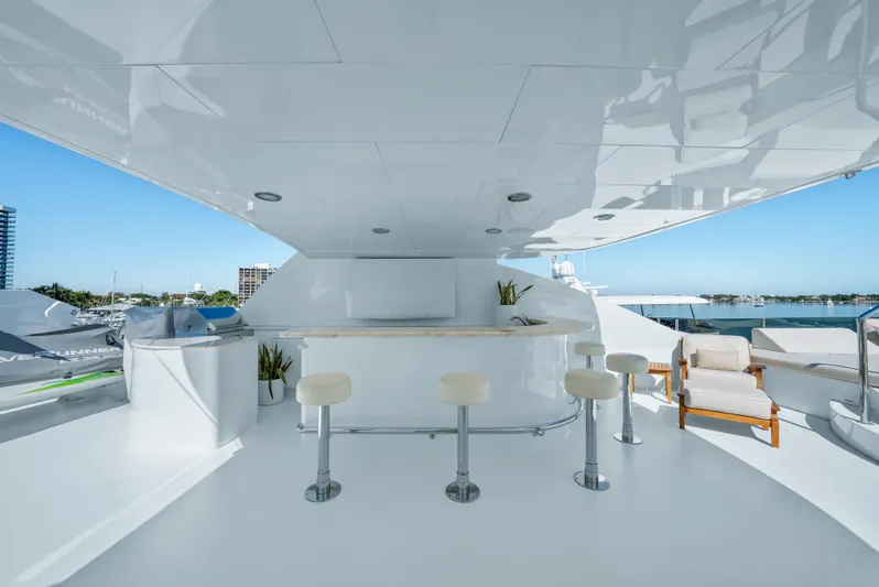 Nicole Evelyn Yacht Photos Pics Luxurious 2005 Trinity Yachts Tri-Deck with sleek outdoor bar and seating area.