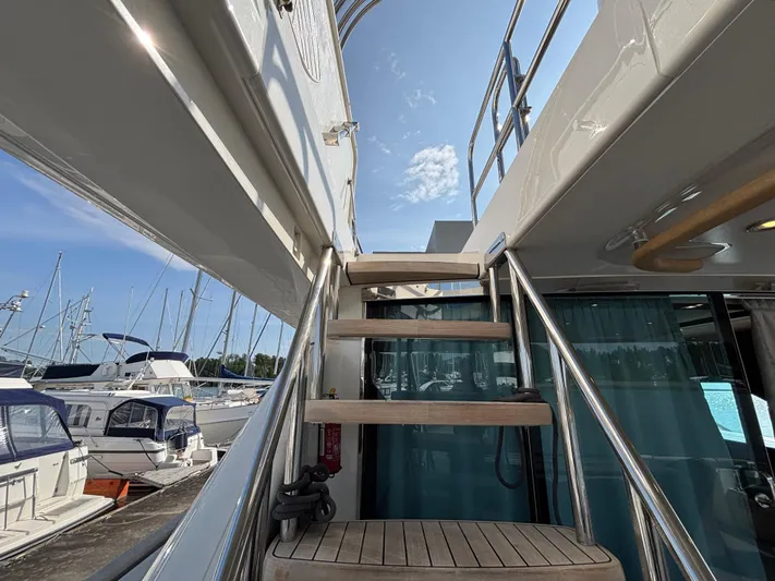 Schatzi Yacht Photos Pics Staircase on 2013 Fairline Squadron 78 Custom yacht, docked at marina under blue sky.